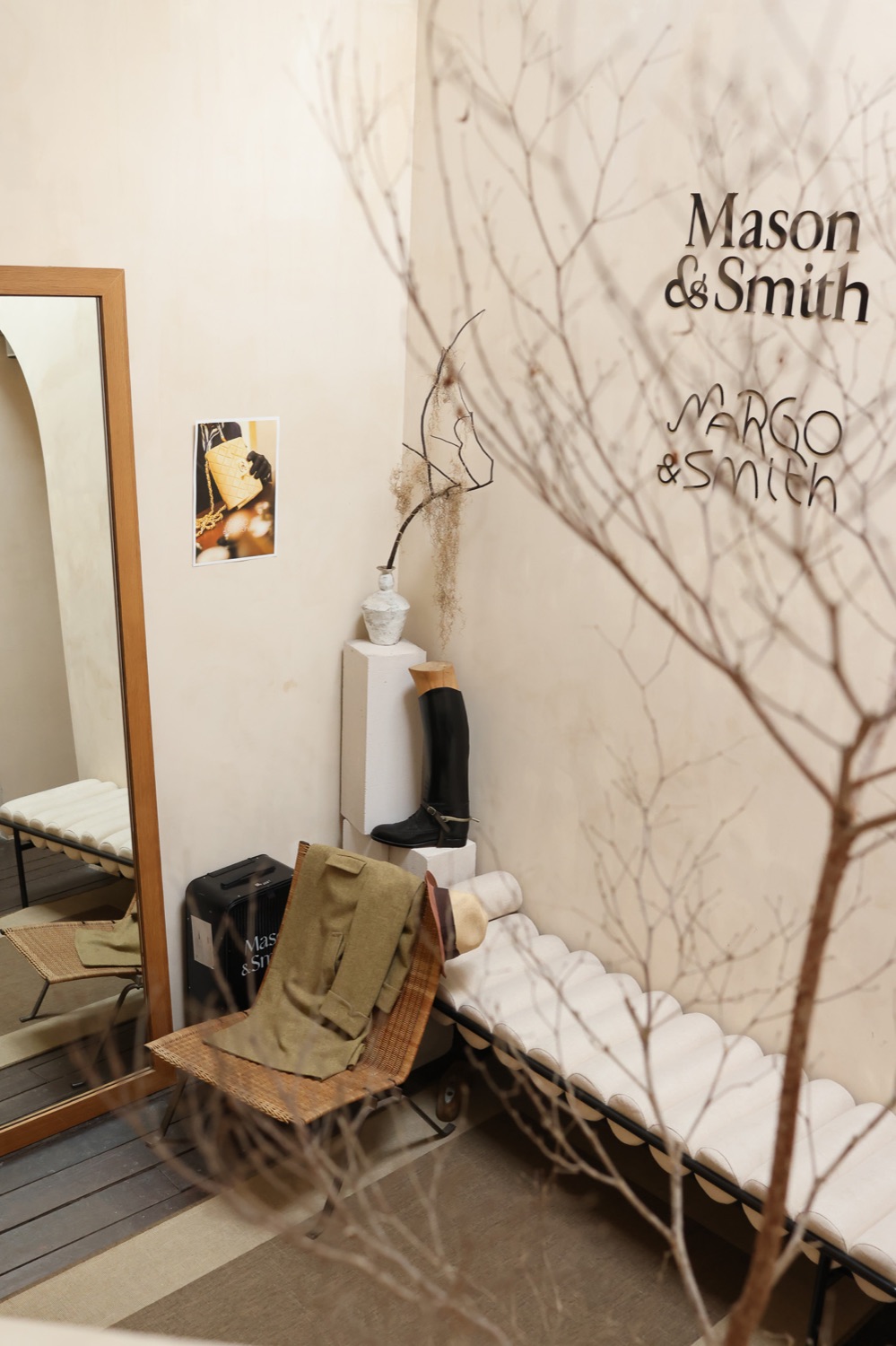 The Mason & Smith and Margo & Smith showroom: a riding boot on a plinth, a rattan chair and the two names on the wall